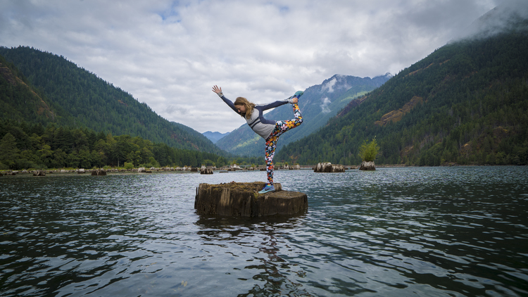 Woman doing yoga on a tree stump at Hood Canal Washington